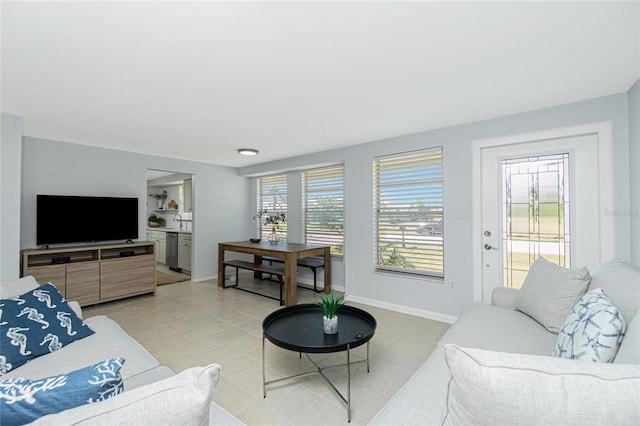 living area featuring light tile patterned floors and baseboards