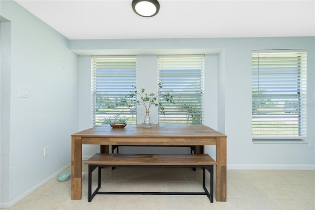 dining room featuring light tile patterned flooring, a wealth of natural light, and baseboards