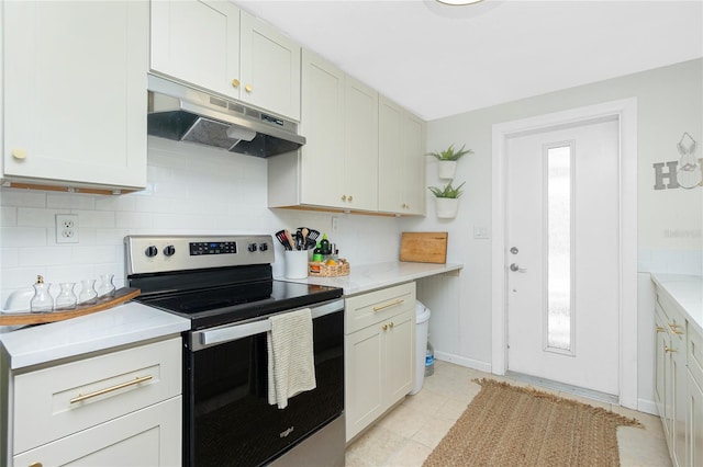 kitchen with electric range, baseboards, under cabinet range hood, and decorative backsplash