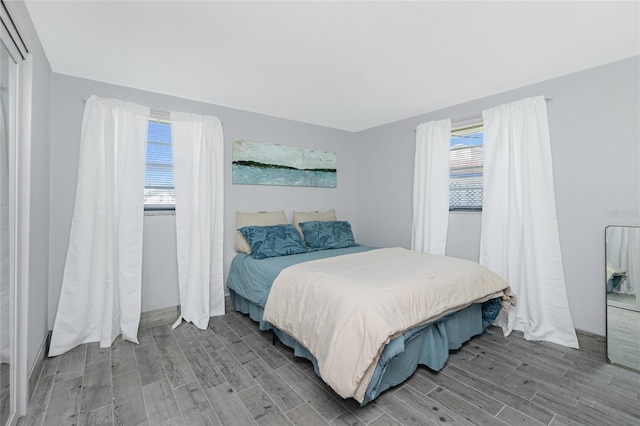 bedroom featuring multiple windows and wood finished floors