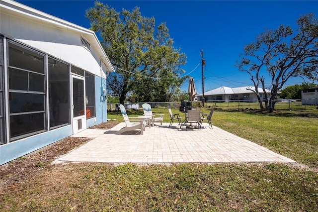 view of patio featuring fence and a sunroom