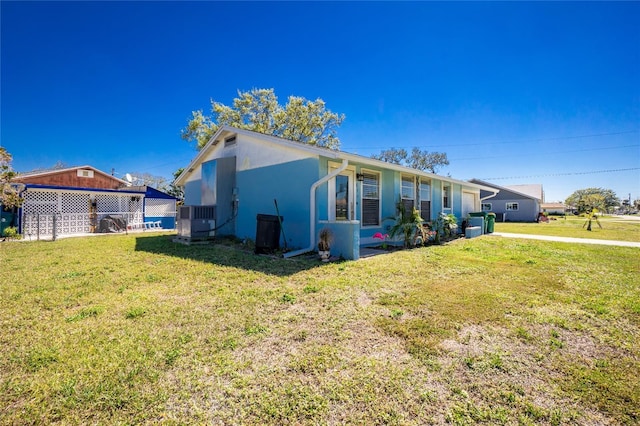 view of side of property with a yard and stucco siding