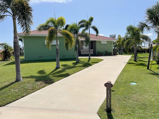 view of front facade featuring a front yard, crawl space, a tiled roof, and concrete driveway