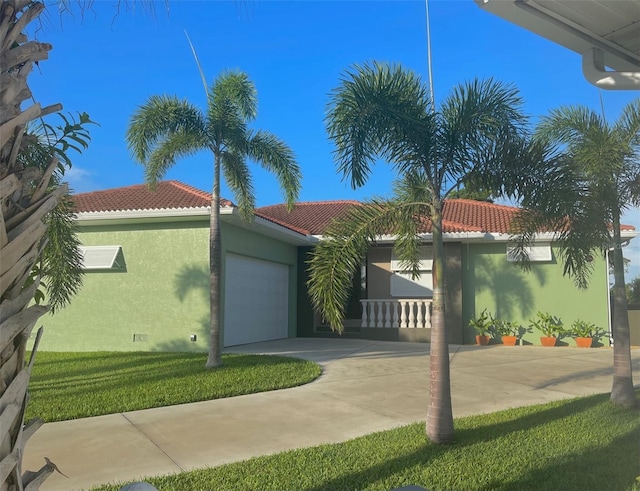 view of front of property with a garage, driveway, a tile roof, and stucco siding