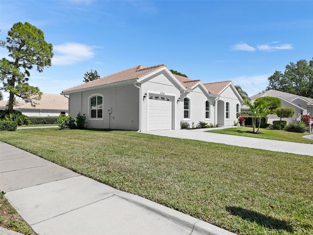 mediterranean / spanish-style house featuring a front yard, concrete driveway, and a tiled roof