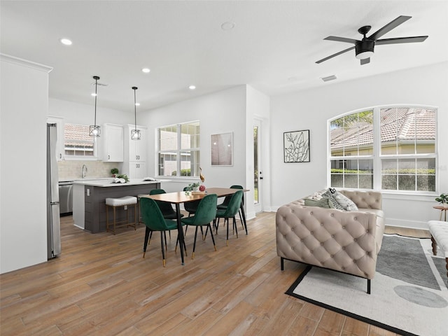 dining space with light wood finished floors, plenty of natural light, visible vents, and recessed lighting