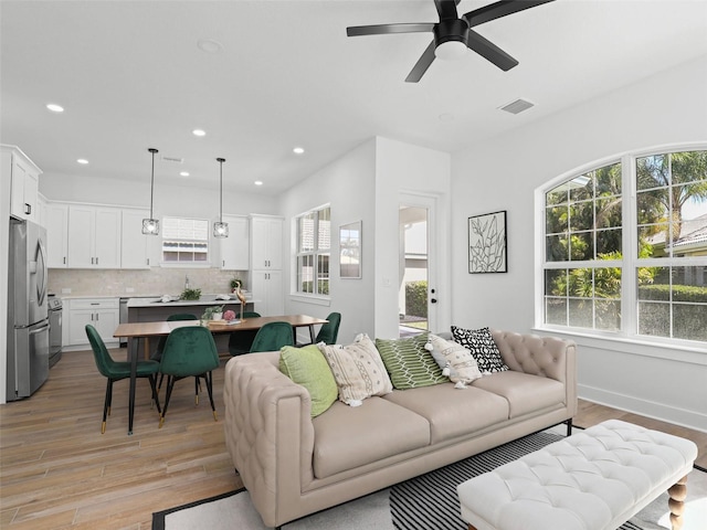 living room featuring recessed lighting, visible vents, and light wood-style flooring