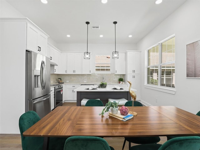 kitchen featuring visible vents, stainless steel appliances, backsplash, and a wealth of natural light