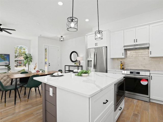 kitchen with decorative backsplash, light wood-style floors, appliances with stainless steel finishes, a center island, and under cabinet range hood