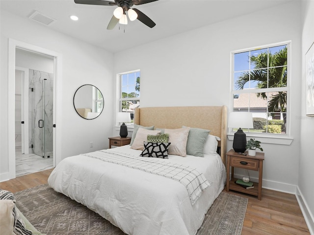 bedroom featuring multiple windows, baseboards, and wood finished floors