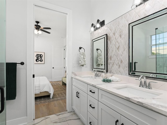 ensuite bathroom featuring marble finish floor, a sink, a ceiling fan, and connected bathroom