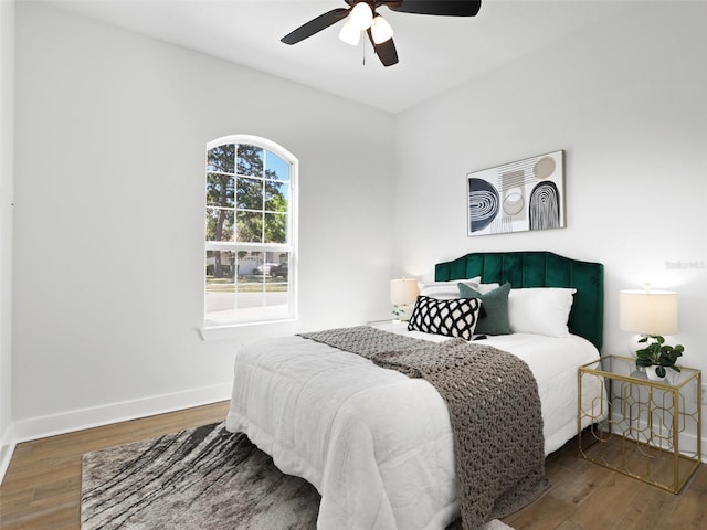 bedroom featuring ceiling fan, baseboards, and wood finished floors