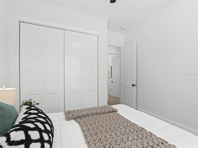 bedroom with a ceiling fan, a closet, visible vents, and baseboards