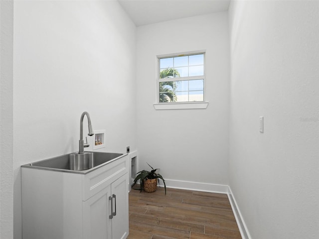 laundry area featuring cabinet space, dark wood-style flooring, hookup for an electric dryer, washer hookup, and a sink