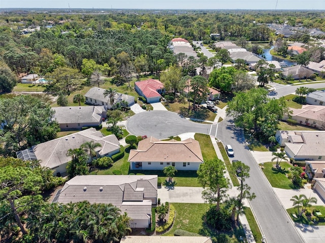 drone / aerial view featuring a residential view and a wooded view