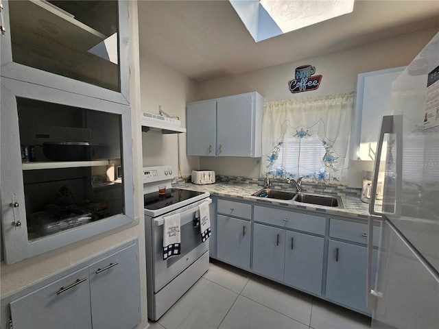 kitchen featuring a skylight, electric range, light countertops, under cabinet range hood, and a sink