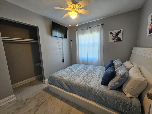 bedroom featuring marble finish floor, a ceiling fan, baseboards, and a closet