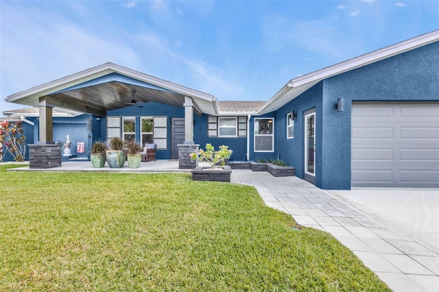 single story home featuring a front lawn, a ceiling fan, and stucco siding