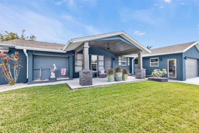 view of front of house with stucco siding, ceiling fan, roof with shingles, an attached garage, and a front yard