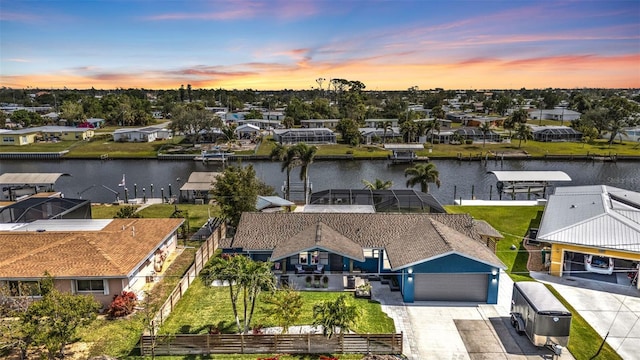 aerial view at dusk with a residential view and a water view