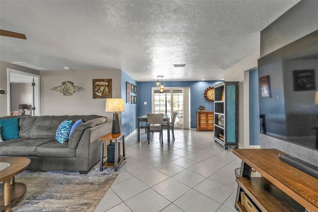 living area featuring light tile patterned floors, visible vents, and a textured ceiling