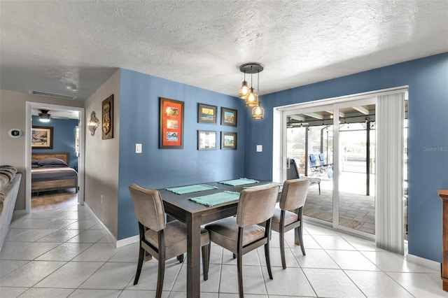 dining space with visible vents, baseboards, a textured ceiling, and light tile patterned flooring