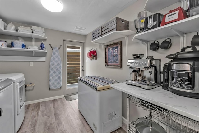 laundry area with laundry area, visible vents, baseboards, light wood-style floors, and independent washer and dryer