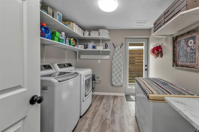 laundry room featuring light wood finished floors, visible vents, washer and dryer, laundry area, and baseboards