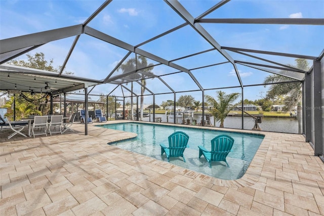 pool with a patio, a water view, and a lanai