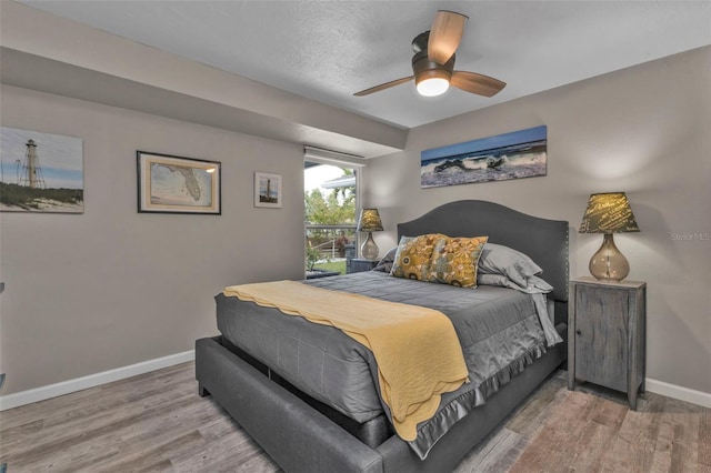 bedroom with ceiling fan, baseboards, and wood finished floors