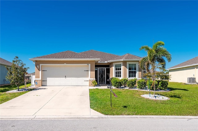 view of front of property with a front lawn, central air condition unit, an attached garage, and stucco siding