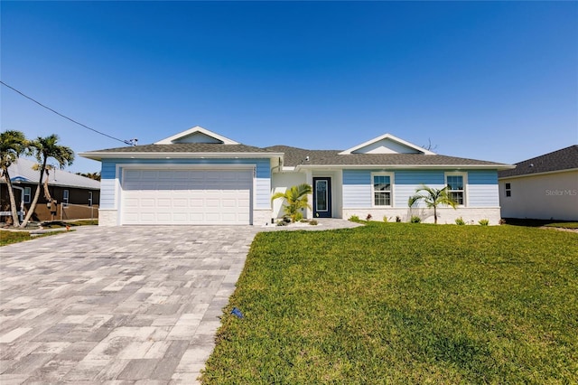 ranch-style house with a front yard, decorative driveway, and an attached garage