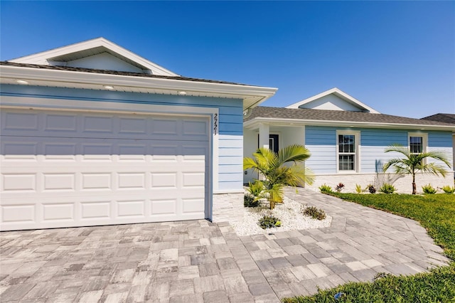 single story home featuring an attached garage and decorative driveway