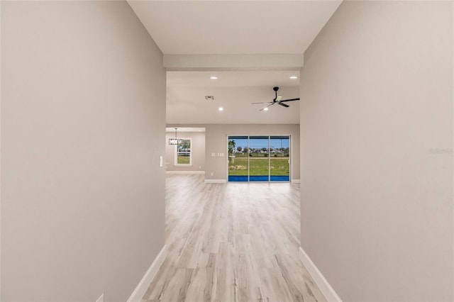 hall with light wood-style flooring, visible vents, baseboards, and recessed lighting