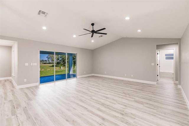 spare room featuring light wood-type flooring, visible vents, vaulted ceiling, and baseboards