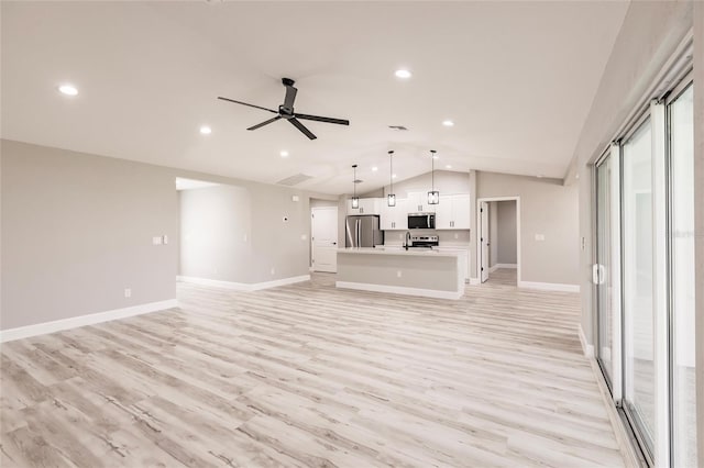 unfurnished living room with ceiling fan, light wood-style flooring, baseboards, and vaulted ceiling