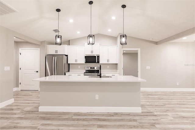 kitchen with a center island with sink, appliances with stainless steel finishes, light countertops, white cabinetry, and a sink