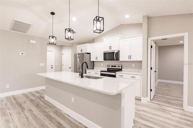 kitchen featuring a center island with sink, stainless steel appliances, visible vents, white cabinets, and a sink