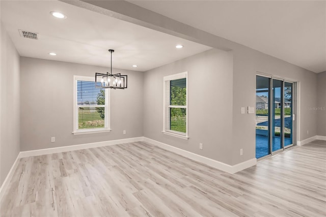 unfurnished room with light wood-type flooring, visible vents, plenty of natural light, and baseboards