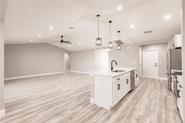 kitchen with a sink, visible vents, white cabinetry, vaulted ceiling, and appliances with stainless steel finishes