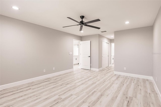 empty room with light wood-style flooring, recessed lighting, visible vents, and baseboards