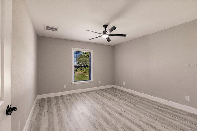 unfurnished room featuring ceiling fan, light wood-style flooring, visible vents, and baseboards