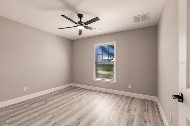 empty room featuring light wood-type flooring, baseboards, visible vents, and ceiling fan