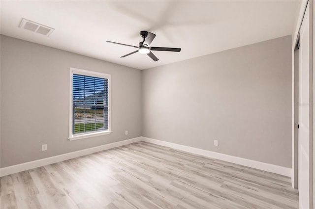 empty room with light wood-type flooring, baseboards, visible vents, and ceiling fan