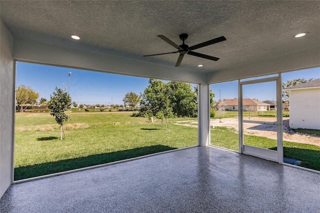 unfurnished sunroom with a ceiling fan