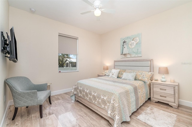 bedroom featuring light wood finished floors, a ceiling fan, and baseboards