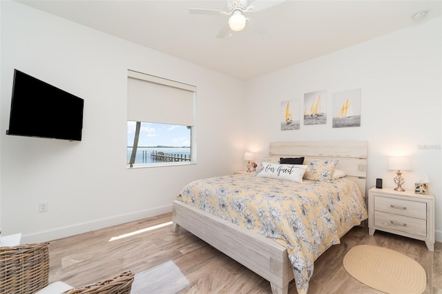 bedroom featuring a ceiling fan, baseboards, and wood finished floors