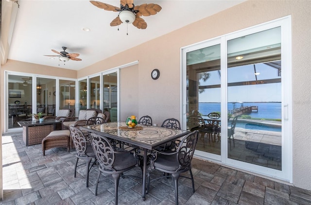 view of patio / terrace featuring outdoor dining area, a ceiling fan, and a water view