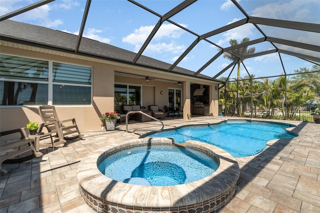 view of pool featuring a ceiling fan, a pool with connected hot tub, a patio, glass enclosure, and outdoor lounge area