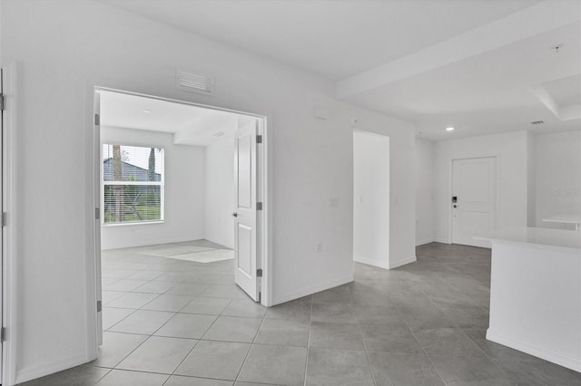 empty room with light tile patterned flooring and baseboards